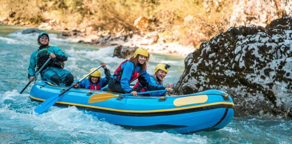 Kelompok peserta arung jeram di sungai berbatu.