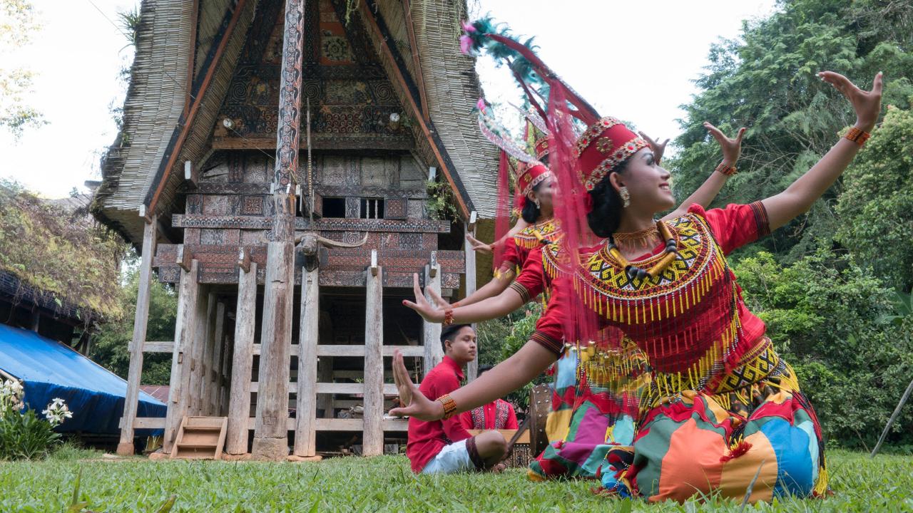 Penari dan pemusik Toraja di depan rumah tongkonan.