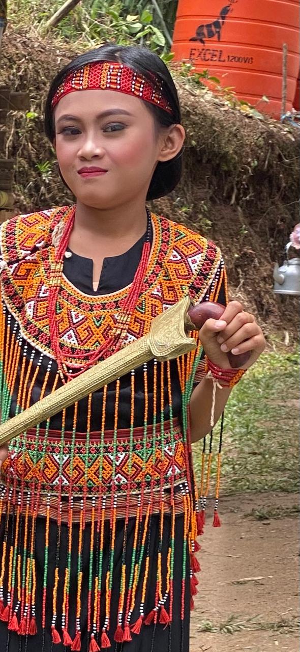 Seorang perempuan mengenakan busana tradisional.