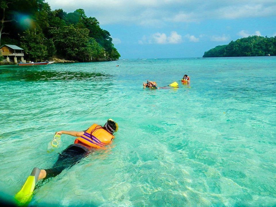 Pengunjung melakukan snorkeling di laut jernih.