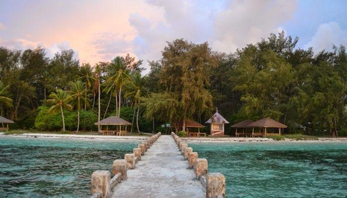 Dermaga batu menuju pantai tropis.